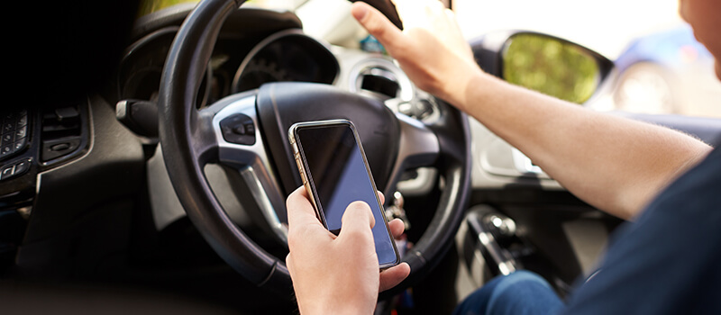 man texting while driving