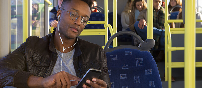 man using phone on bus