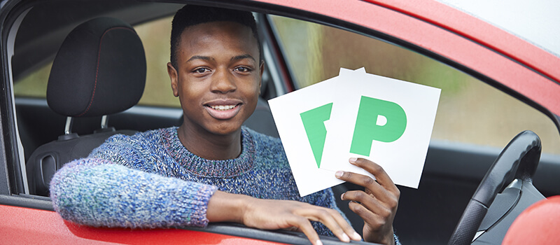 boy holding p plates in car