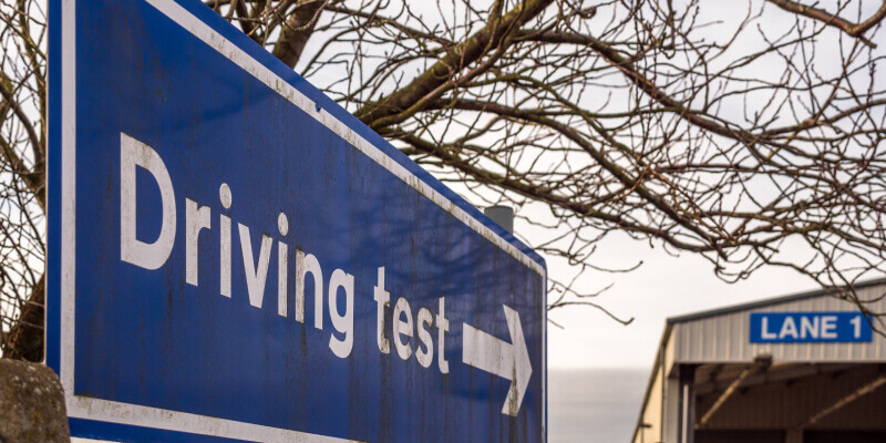 Sign with an arrow that reads: driving test