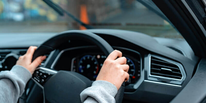 Hands gripping steering wheel