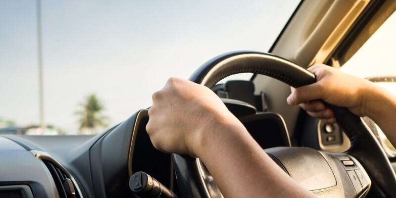 Hands placed on steering wheel